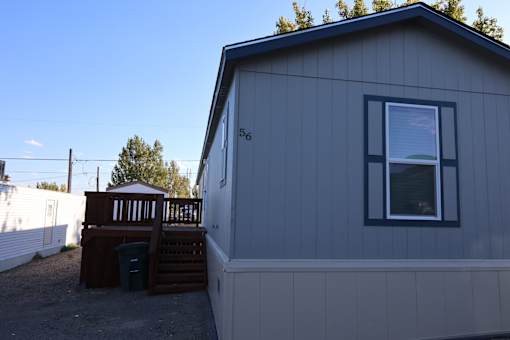 the exterior of a tiny house with a deck and a window at Horizon MHC, Rock Springs, Wyoming