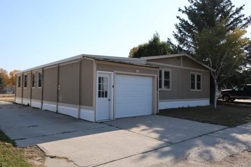 the front of the home has a driveway and a white garage door at Kimberly Village, Cheyenne, WY, 82007