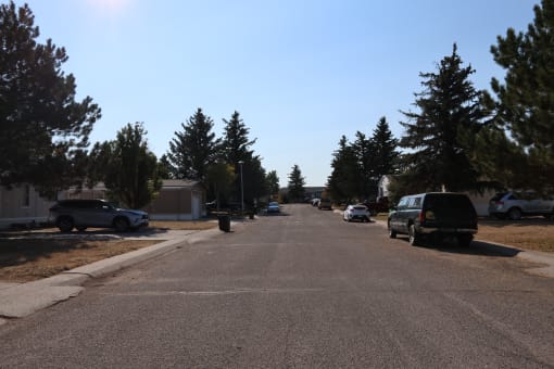 a street with cars parked on the side of it and trees at Kimberly Village, Cheyenne, Wyoming