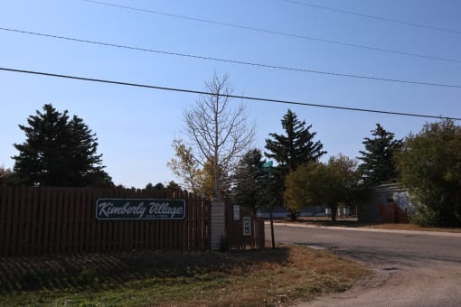 a wooden fence with a sign on the side of a road at Kimberly Village, Wyoming