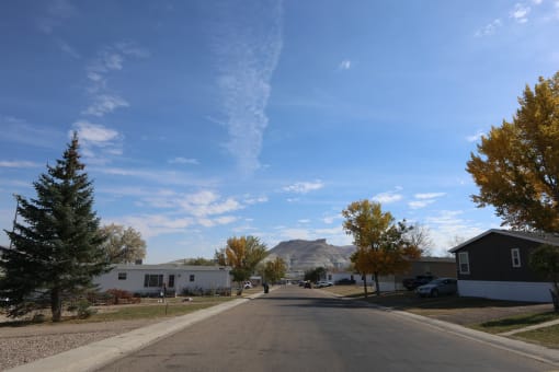 a street with houses and trees and a mountain in the background at Pioneer Park, Green River, 82935
