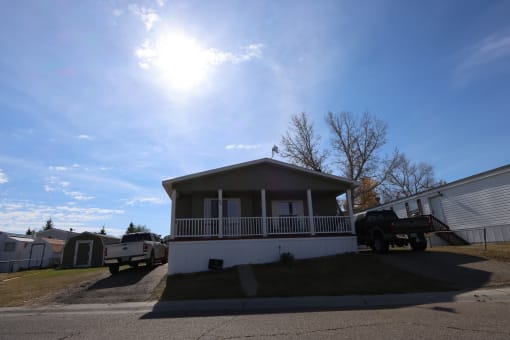 a small house with a truck parked in front of it at Pioneer Park, Wyoming