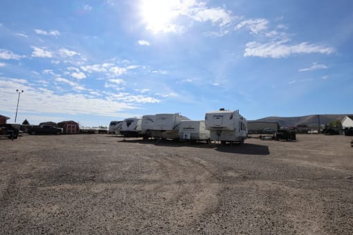 a row of travel trailers parked in a dirt lot under a blue sky at Pioneer Park, Green River, Wyoming