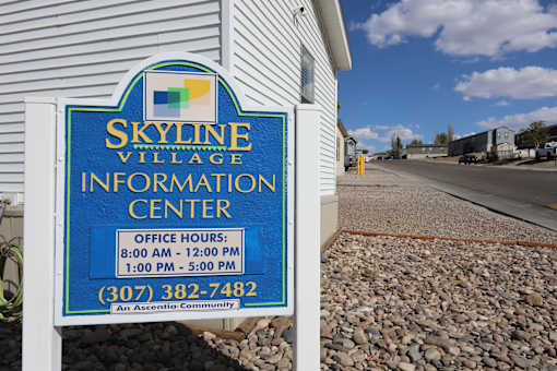 A sign for the Skyline Village Information Center with office hours listed.