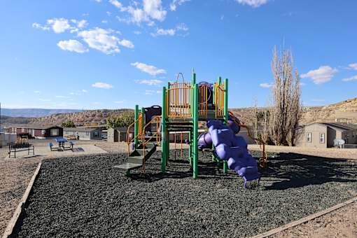 A playground with a purple slide and green and yellow play structure.