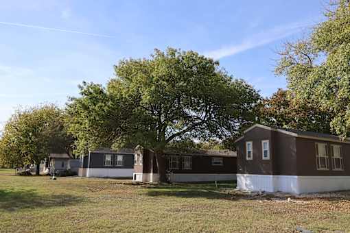 A row of houses with trees in the background.