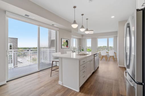 an open kitchen and dining area with a balcony