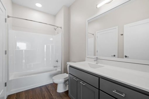 a bathroom with a large mirror and a toilet and a shower