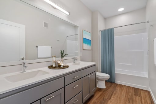 a bathroom with two sinks and a toilet and a shower