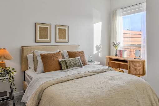 A bedroom with a large bed and two framed pictures on the wall.
