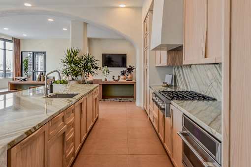 A kitchen with wooden cabinets and a marble countertop.