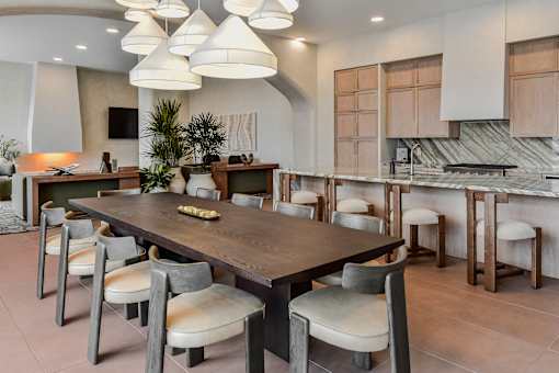 A modern dining room with a large table and chairs.