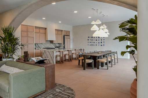 A living room with a couch, chairs, and a dining table.