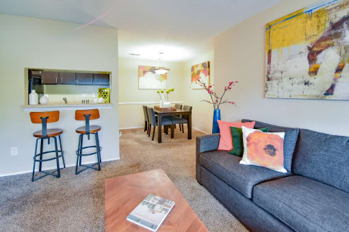 a living room with a couch and a table with stools  at Riverset Apartments, Tennessee