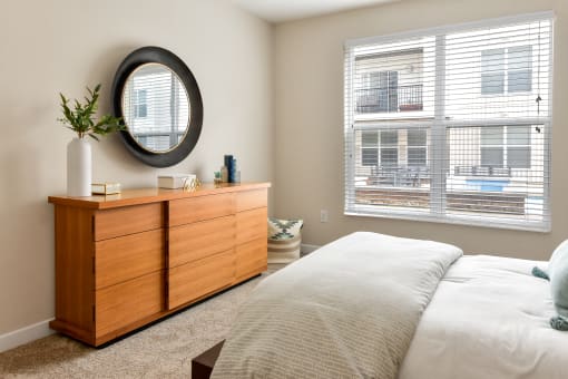a bedroom with a bed and a dresser and a window