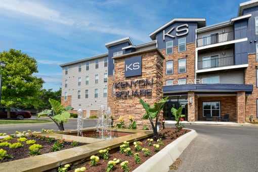 Apartments in Westerville, OH with In-Unit Washer and Dryer - Kenyon Square - Apartment Building Exterior with Stone Details, Private Balconies, and Beautiful Landscaping with a Water Fountain