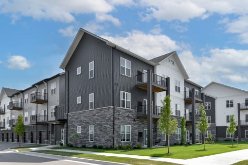 an exterior view of an apartment building on a city street at The Commons at Rivertown, Grandville, Michigan