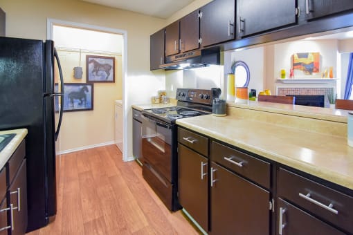 a kitchen with black cabinets and wood floors  at Riverset Apartments, Memphis