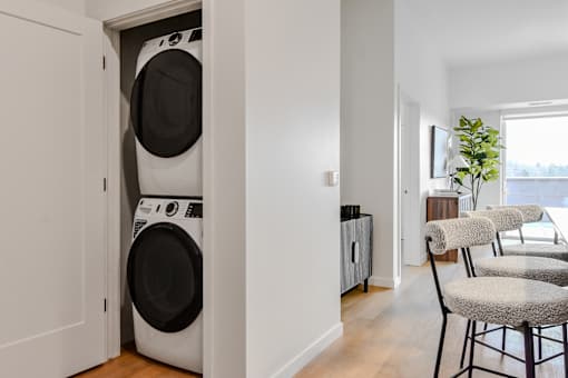 A white washing machine is in a small laundry room.