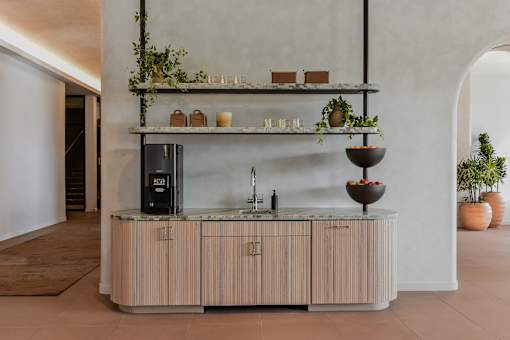 A modern kitchen with a wooden counter and a black fridge.