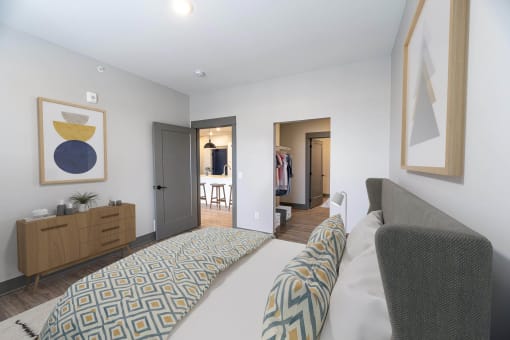 a bedroom with a bed and a dresser and a closet at The Commons at Rivertown, Grandville
