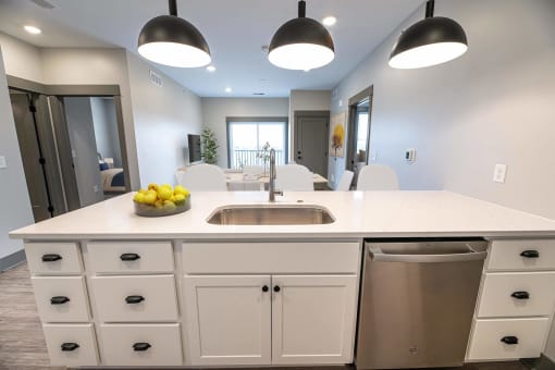 a kitchen with a large island and a dishwasher in a new home at The Commons at Rivertown, Grandville, MI, 49418