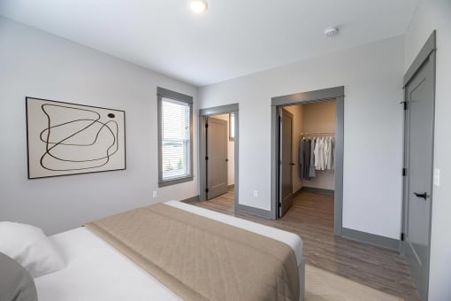 a bedroom with a large bed and a walk in closet at The Commons at Rivertown, MI