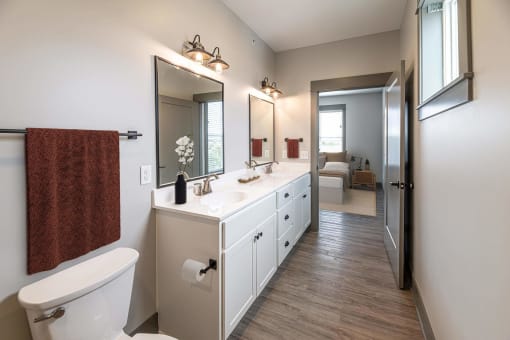 a bathroom with a large mirror and a toilet at The Commons at Rivertown, Grandville