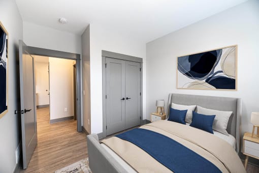 a bedroom with a bed and a door to a bathroom at The Commons at Rivertown, Grandville, MI, 49418