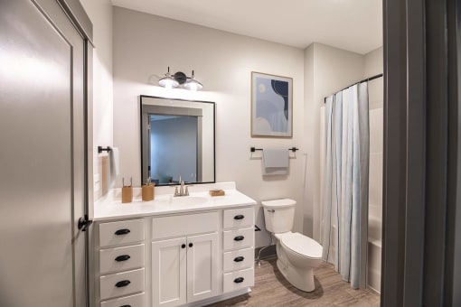 a bathroom with a sink and a toilet and a shower at The Commons at Rivertown, Grandville, MI