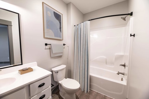 a bathroom with a shower and a toilet and a sink at The Commons at Rivertown, Grandville, MI, 49418