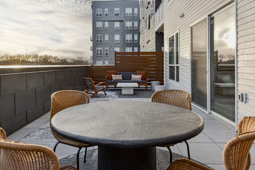 A patio with a table and chairs is set up on a balcony.