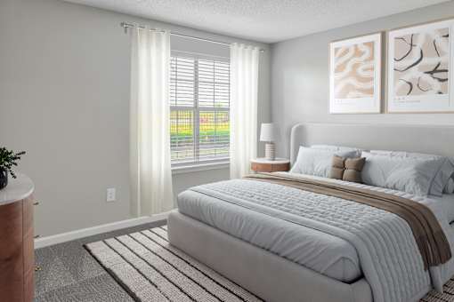 A bedroom with a large bed and a window with blinds.