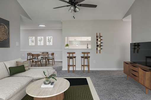 A living room with a white couch, a round table, and a ceiling fan.