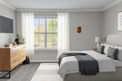 A bedroom with a large bed and a window with white curtains.