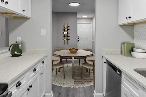 A kitchen with a table and chairs in the middle.