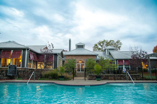a swimming pool in front of a brick building with a metal roof  at Riverset Apartments, Tennessee