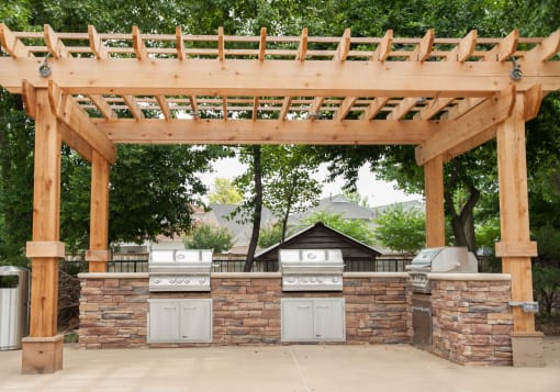 an outdoor kitchen with a pergola and barbecue  at Riverset Apartments, Tennessee, 38103