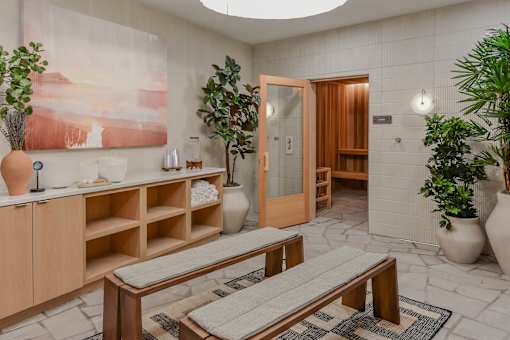 A room with a wooden bench and a painting on the wall.