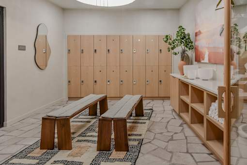 A room with wooden benches and lockers.