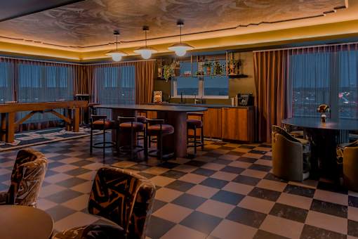 A black and white checkered floor in a room with a bar.