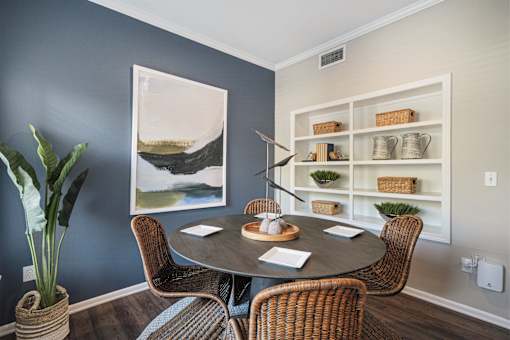 A dining room with a round table and chairs.