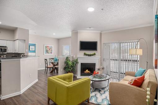 A living room with a yellow chair and a fireplace.