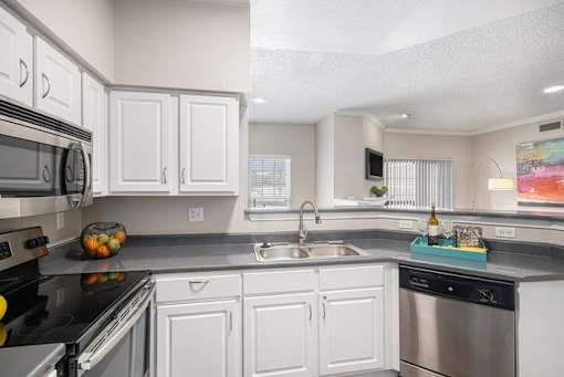 A kitchen with white cabinets and stainless steel appliances.