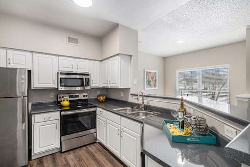 A kitchen with white cabinets and a black stove top.
