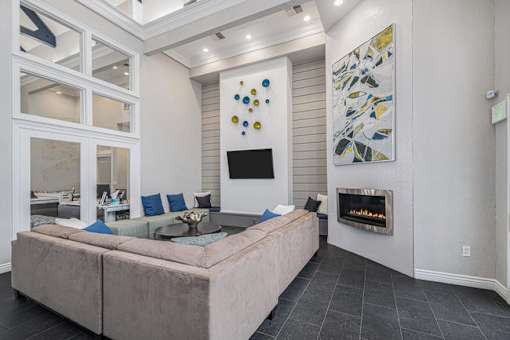 A modern living room with a fireplace and a painting on the wall.