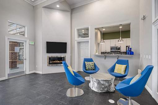 A living room with a fireplace and blue chairs.