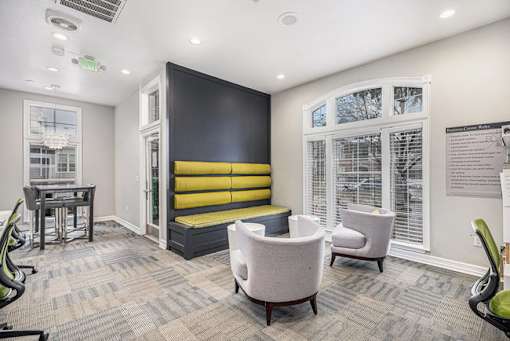 A room with a yellow bench and grey chairs.