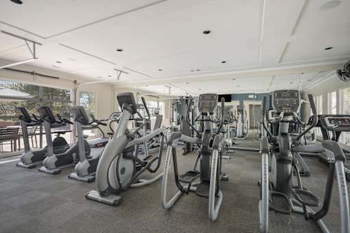 A gym with a row of stationary bikes.