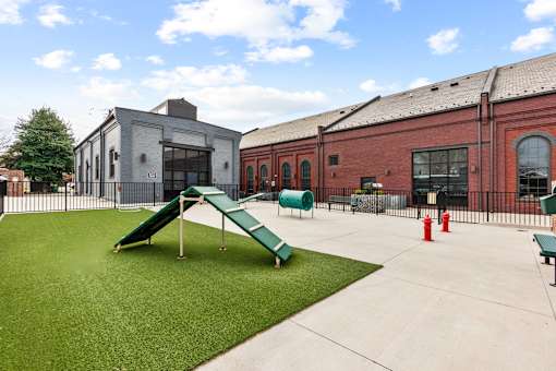 A playground with a green slide and a red fire hydrant.